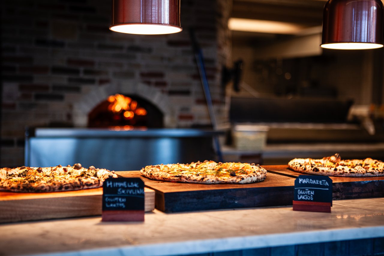Lunchbuffén: nybakade pizzor uppdukade framför vedugnen